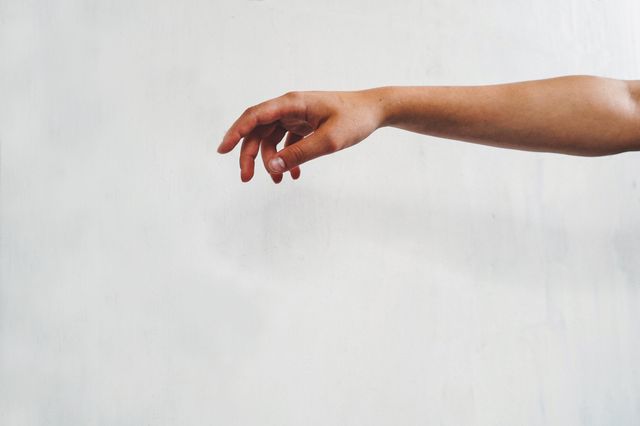 This visual showcases a single outstretched arm with a hand reaching in front of a clean, light grey background. Useful for themes emphasizing simplicity, human connection, or gestures. Ideal for promotional materials related to wellness, self-help, and human body anatomy. Can also be used as a visually clean illustration for design projects needing minimalistic human elements.