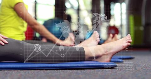 Women stretching on mats in gym class with barefoot focus and digital fitness data overlay
