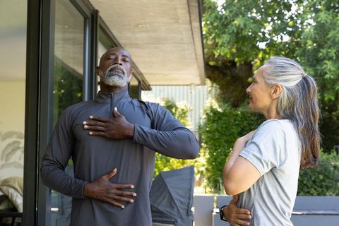 Senior couple practicing deep breathing on home patio promoting mindfulness and wellness