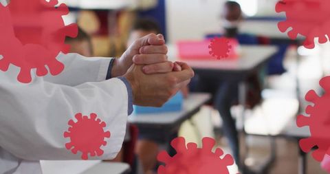 Teacher sanitizing hands in classroom with virus overlays