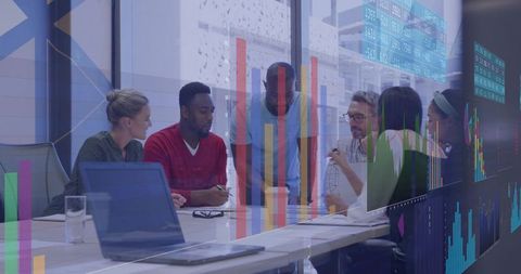 Diverse Team Collaborating Over Data Visualizations and Charts in Modern Boardroom