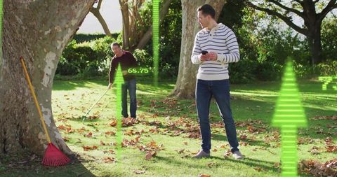 Man holding smartphone monitoring raking with ar overlays in autumn park