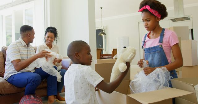 Happy African American Family Unpacking Boxes in New Home - Download Free Stock Images Pikwizard.com