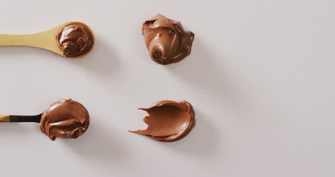 Smooth Chocolate Cream Dollops on Spoons and Surface