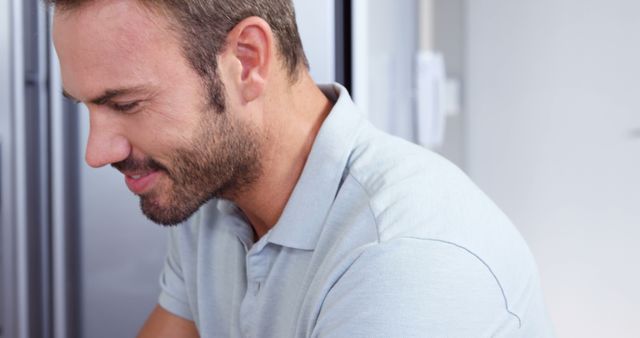 Man Smiling While Working from Home in Light Blue Polo Shirt - Download Free Stock Images Pikwizard.com