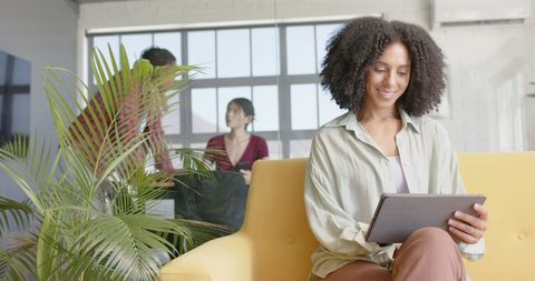 Businesswoman Engaging with Tablet in Collaborative Office Space - Download Free Stock Images Pikwizard.com