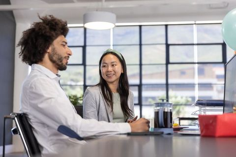 Diverse coworkers engaging in office meeting with modern workspace
