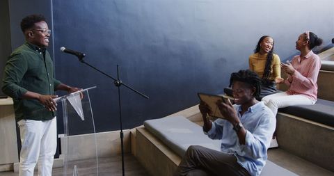 Man receiving award on stage amid applause in office celebration