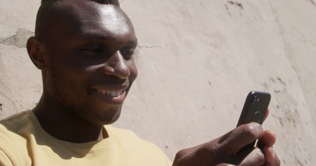 Smiling African American Young Man Texting with Smartphone - Download Free Stock Images Pikwizard.com