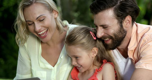 Happy Family Watching Something on Tablet in Park - Download Free Stock Images Pikwizard.com