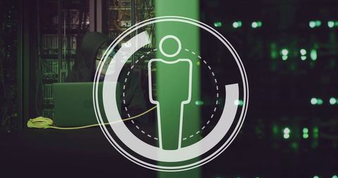 Hacker Using Laptop to Navigate Cyber Data in Server Room