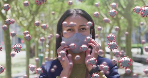 Woman Wearing Mask in Park Surrounded by Illustrative COVID-19 Cells - Download Free Stock Images Pikwizard.com