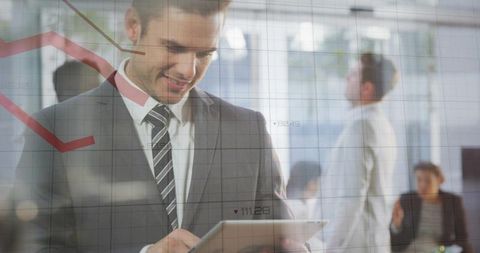 Businessman analyzing financial data on tablet with overlaid graphs in modern office