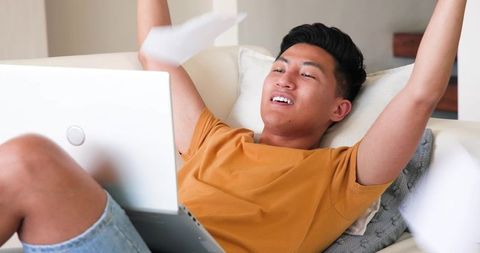 Excited Man Celebrating Success Working from Laptop at Home