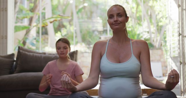 Pregnant Woman Practicing Meditation with Young Girl at Home - Download Free Stock Images Pikwizard.com