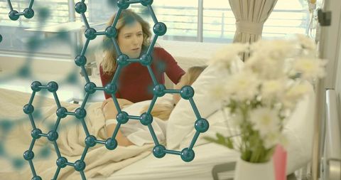 Woman comforting patient in hospital bed with molecular hexagon overlay