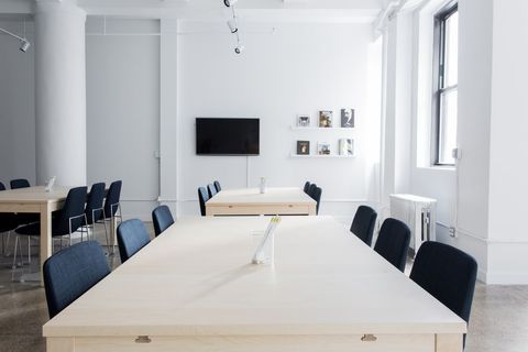 Minimalist Conference Room with Wooden Tables and Black Chairs
