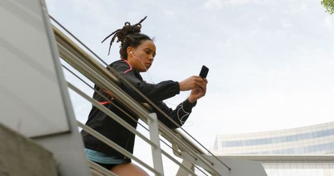 Young Woman with Phone on City Bridge, Listening Music Focusing
