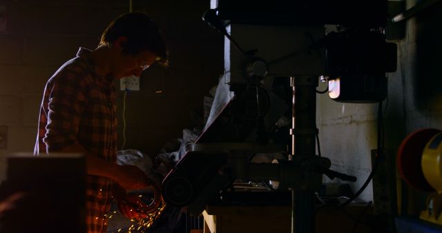 Silhouette of Young Male Engineer Working in Workshop with Metal Grinder - Download Free Stock Images Pikwizard.com