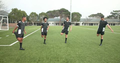 Soccer Players Stretching on Field for Practice Preparation