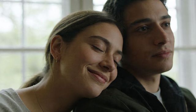 Young couple resting together by sunlit window showing tenderness and quiet intimacy