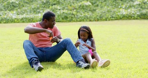 Father and Daughter Bonding Outdoors Blowing Bubbles