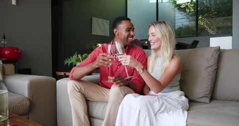 Couple Toasting Celebration at Home with Champagne Glasses