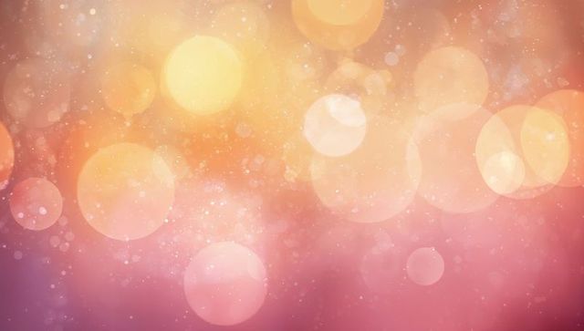 Warm golden-pink bokeh background with glowing orbs, soft sparkles and light haze