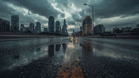 Moody urban landscape with wet reflective roadway