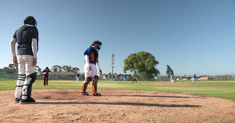 Youth baseball catcher in action on sunlit sports field