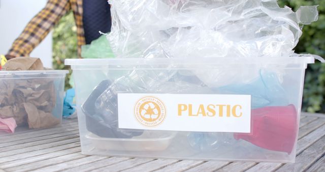 Plastic waste collected in clear recycling bin. Perfect for campaigns promoting sustainability, eco-friendly waste management, and environmental conservation. Can be used in articles discussing household recycling practices and community recycling programs.