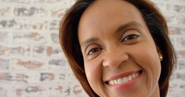 Front view of mature black woman looking at camera in a comfortable home. Close-up of smiling mature woman 4k
