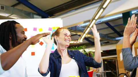 Team Celebrating Success at Creative Workspace with High Fives