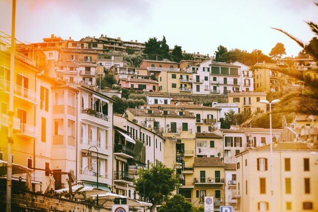 Features a scenic hillside village with colorful buildings during sunset. Ideal for travel brochures, real estate advertisements, or as a background image for websites promoting tourism in Mediterranean regions.