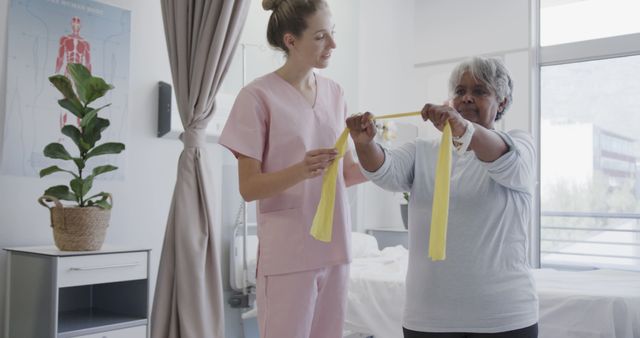 Physical therapist helping elderly woman with resistance band exercises - Download Free Stock Images Pikwizard.com