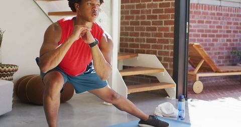 African American Man Exercising with Stretching Routine at Home