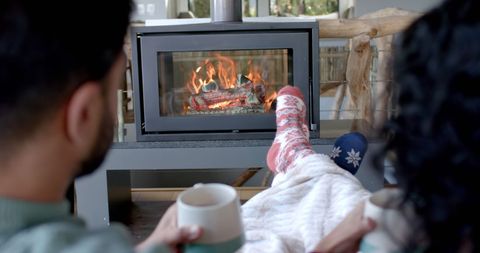 Cozy Couple Enjoying Hot Drinks by the Fireplace
