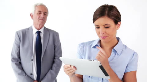 Young Professional Using Tablet with Collegue in Background