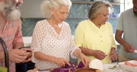 Senior Friends Cooking Together in Modern Kitchen