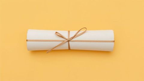Rolled parchment scroll with bow on yellow background
