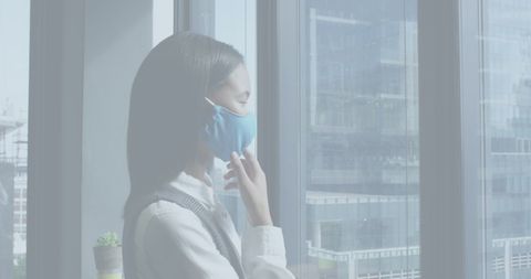 Businesswoman in Office Wearing Mask Observing Cityscape