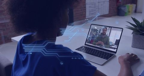 Remote collaboration on laptop with holographic data overlay at modern coworking desk