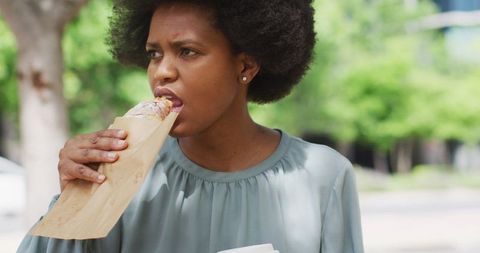City Businesswoman Eating Pastry Outdoors