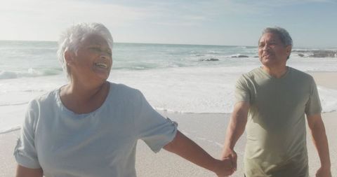 Happy Senior Couple Enjoying Walk on Beach at Sunset