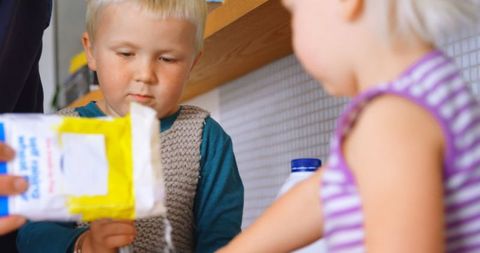 Father Helping Young Children Bake in Kitchen