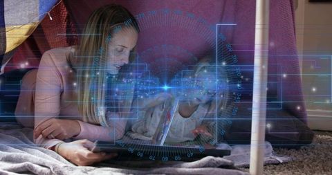 Mother and daughter in blanket fort using tablet with futuristic digital hud for bonding