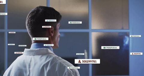 Scientist standing by frosted glass displaying digital id overlays and clinical data tags