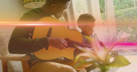 African American Father and Son Bonding Through Playing Guitar