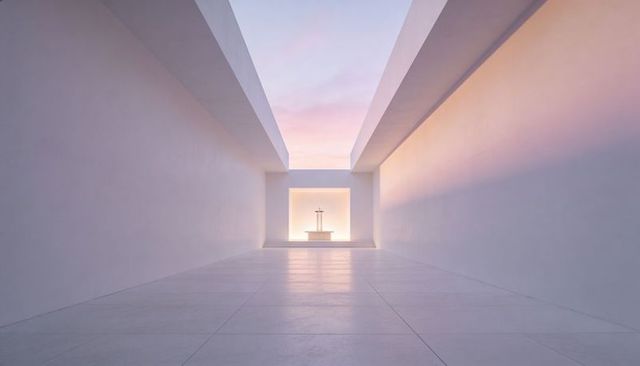 Minimalist white corridor leading to backlit altar with cross under soft sunrise glow