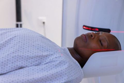 African male patient undergoing head ct scan with laser positioning in radiology suite